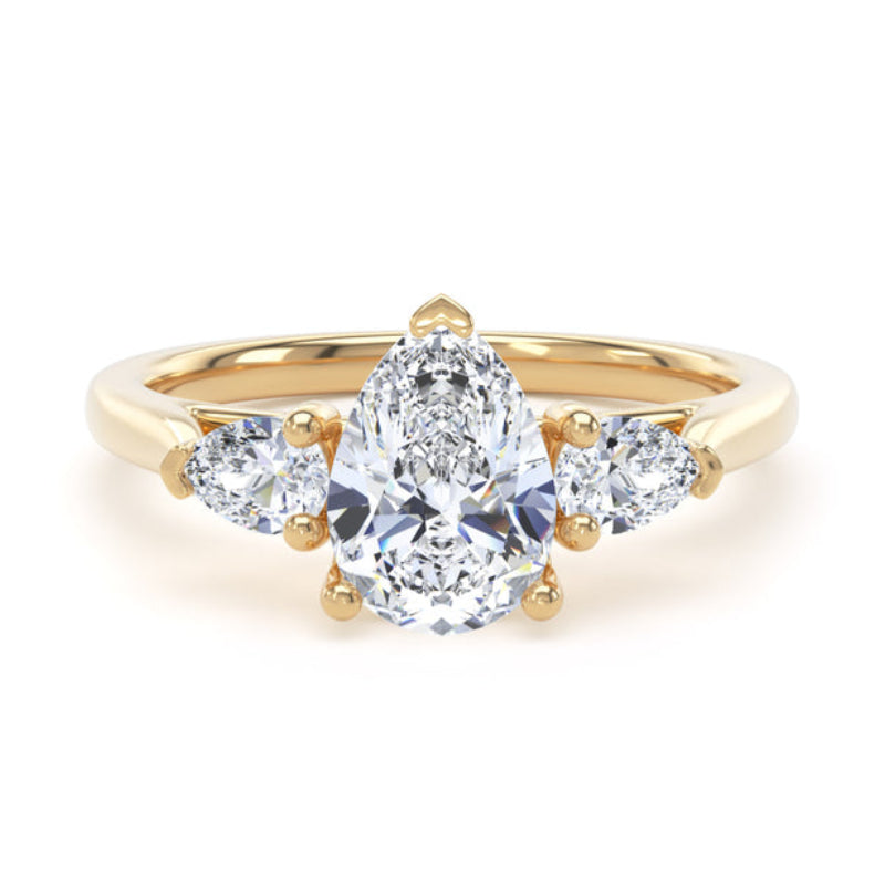 A yellow gold ring featuring a pear-cut center diamond flanked by two smaller round diamonds on the shoulders, set against a plain white background.