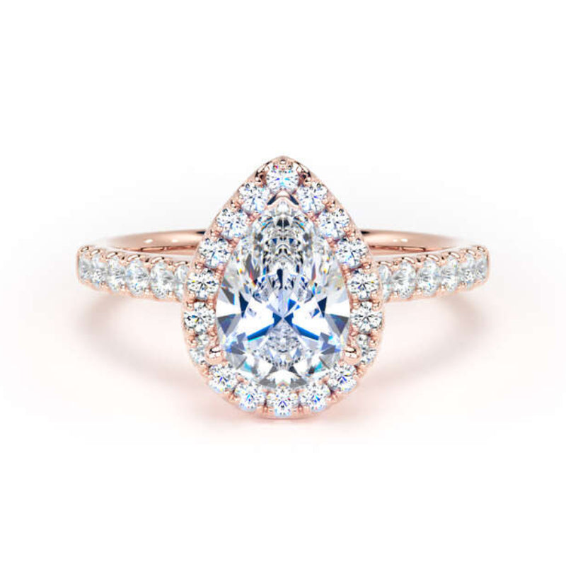 A pear-cut halo ring featuring a central blue sapphire surrounded by small clear stones, set on a rose gold band with pavé accents, shown on a white background.