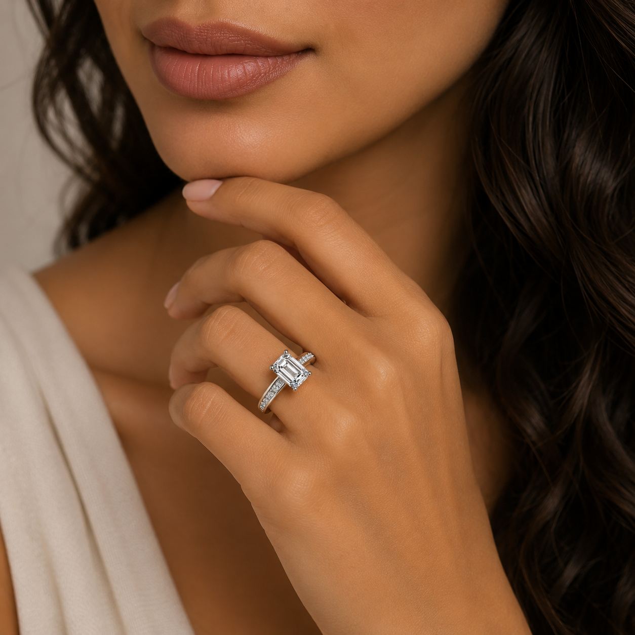 Close-up of a woman's hand wearing a diamond ring with a neutral background