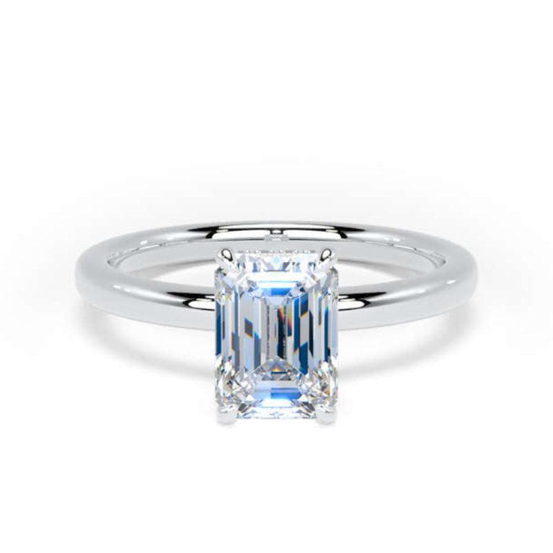 An emerald-cut diamond solitaire ring in a polished silver-colored metal band, set against a plain white background.
