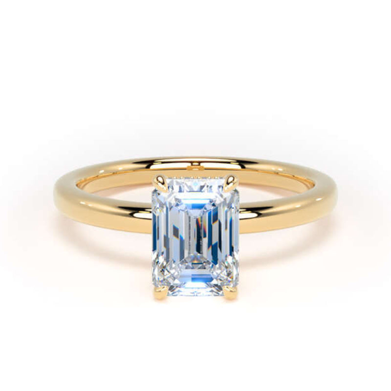 A yellow gold ring with a rectangular emerald-cut light blue gemstone, shown on a clean white background.