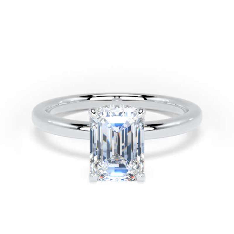 An emerald-cut diamond ring with a polished silver-colored band, centered on a clean white background.