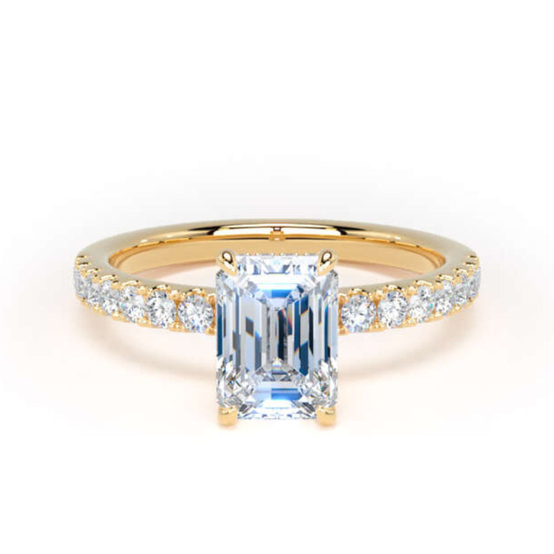A yellow gold ring featuring a large emerald-cut light blue center stone and a pavé-set diamond band, shown on a clean white background.