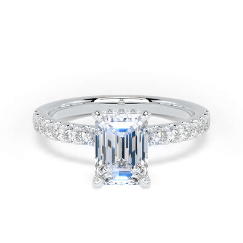 An emerald-cut diamond engagement ring with a silver-colored band accented by pavé diamonds, set against a plain white background.