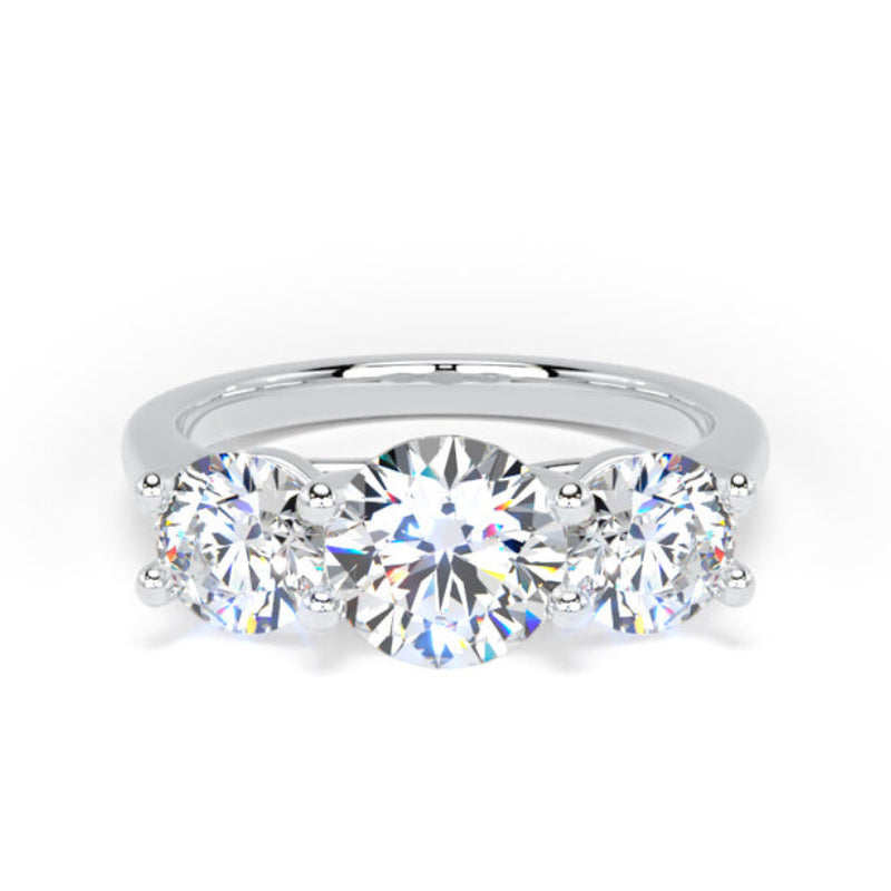 A three-stone diamond ring with a brilliant round center diamond and two round brilliant side diamonds, set in a polished silver-colored metal band on a white background.