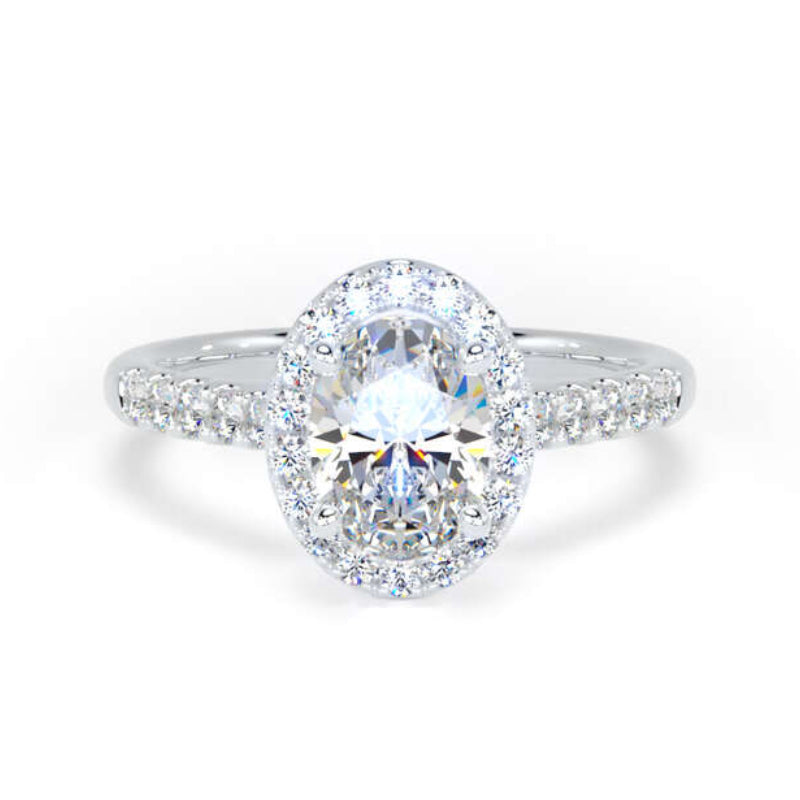An oval halo engagement ring featuring a brilliant round-cut center stone surrounded by a halo of smaller round stones, with a pavé-set band in a silver-colored metal, shown on a plain white background.
