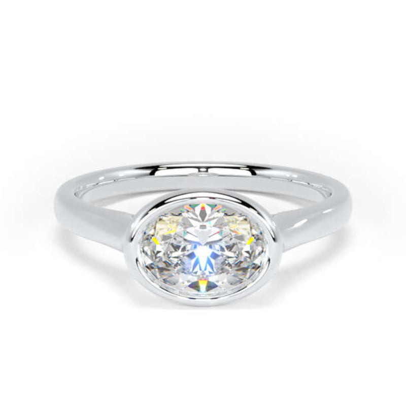 A silver oval ring with a brilliant round-cut clear gemstone, shown on a clean white background.