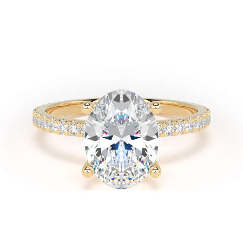 A yellow gold engagement ring featuring a large oval-cut center diamond set in a four-prong setting, with a pavé band accented by small round diamonds, shown on a clean white background.