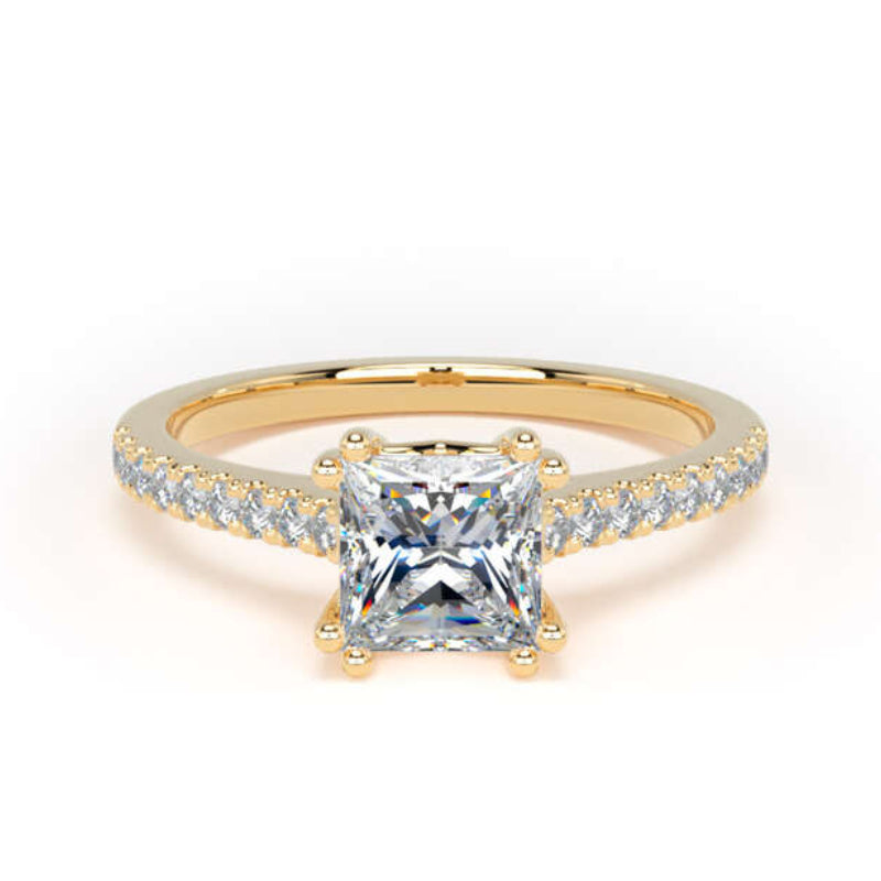 A yellow gold ring featuring a princess-cut clear center stone and pavé-set side stones on a white background.