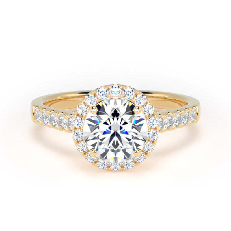 A yellow gold halo engagement ring featuring a round brilliant-cut center diamond surrounded by a halo of smaller diamonds, with additional diamonds set along the split shank, shown on a clean white background.