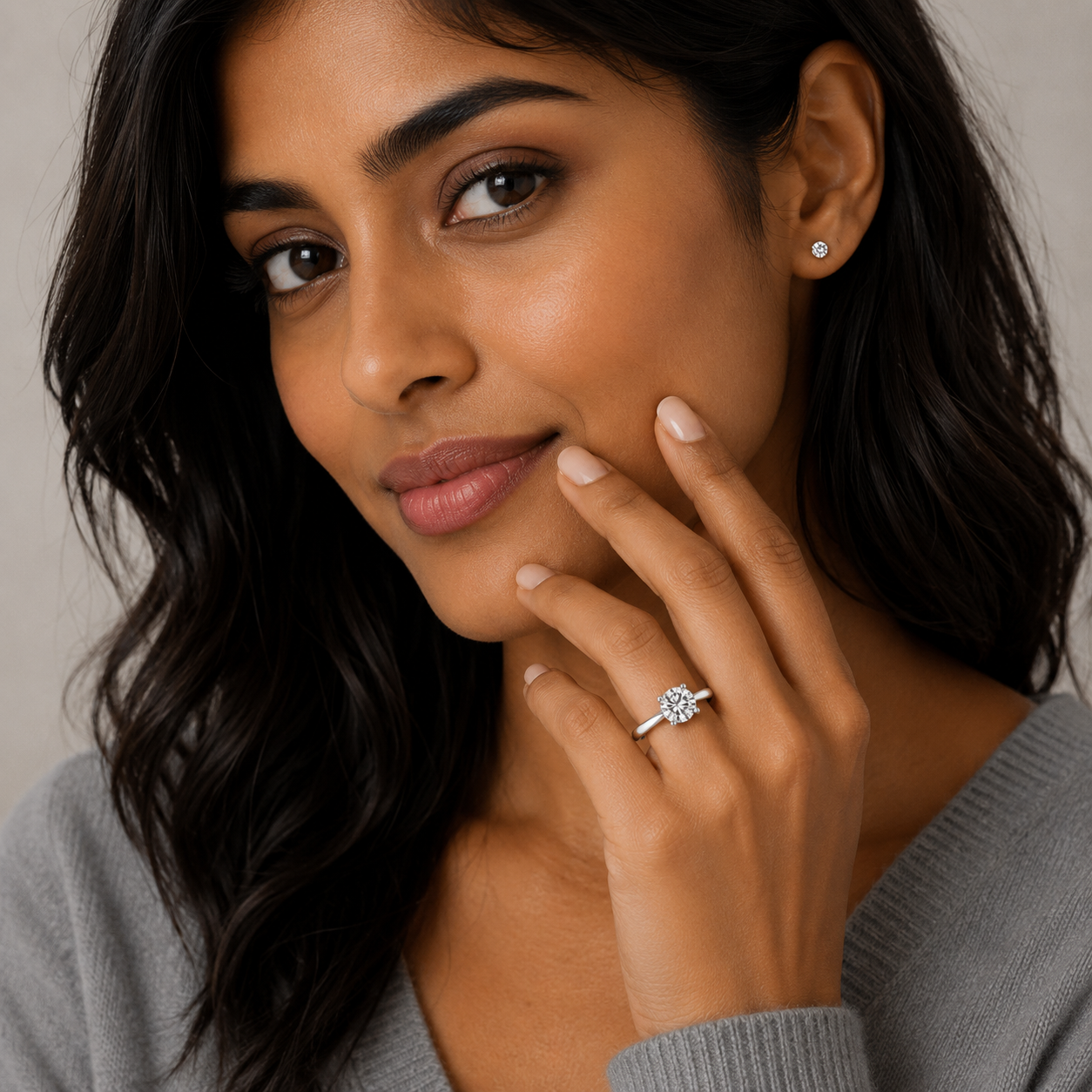 Woman wearing a diamond ring with a neutral background