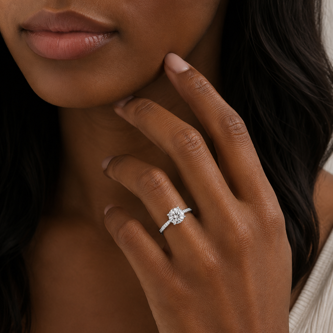 Close-up of a hand wearing a diamond ring with a blurred background