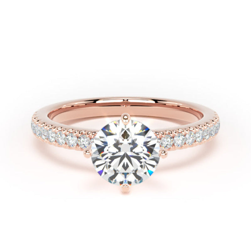 A rose gold engagement ring featuring a round brilliant-cut center stone and a pavé band with small accent stones, set against a plain white background.