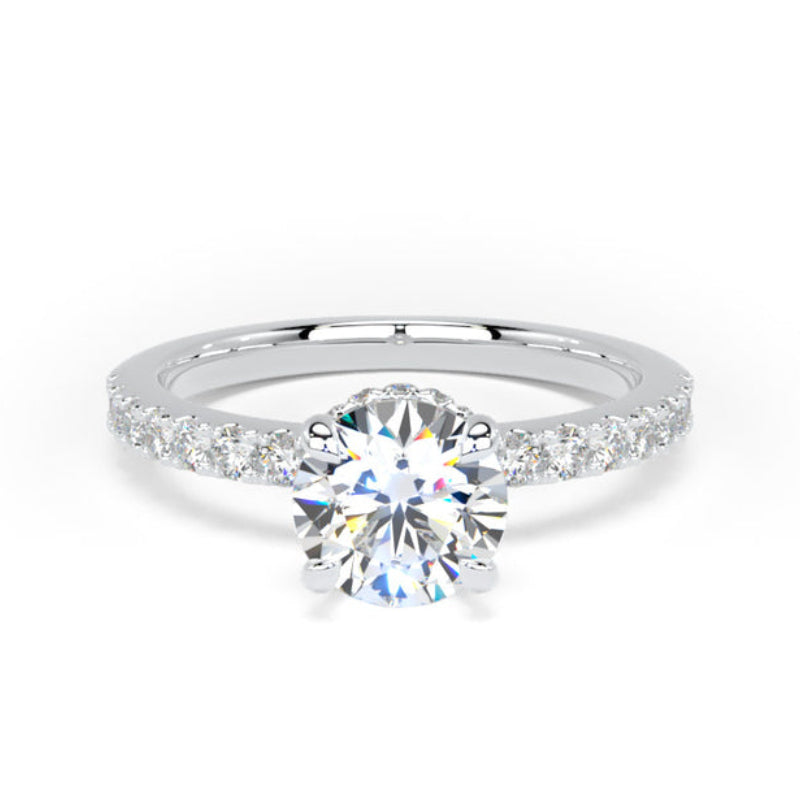 A white gold or platinum solitaire engagement ring featuring a round brilliant-cut center stone and a pavé band with small accent stones, shown on a clean white background.