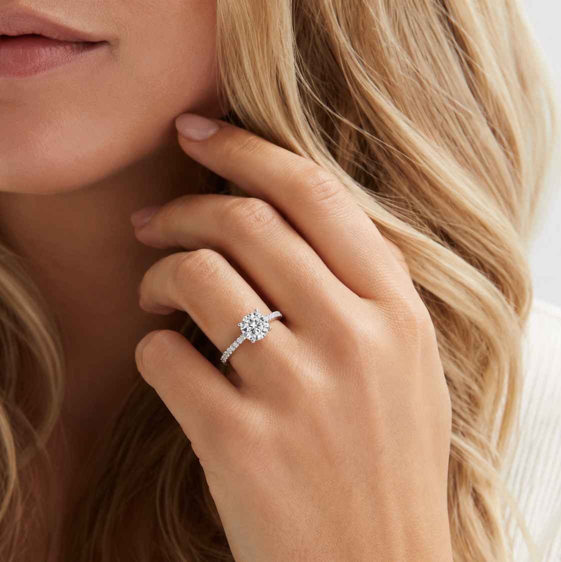 Close-up of a hand wearing a diamond ring with a blurred background