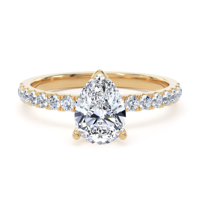 Gold ring with a pear-shaped diamond on a white background