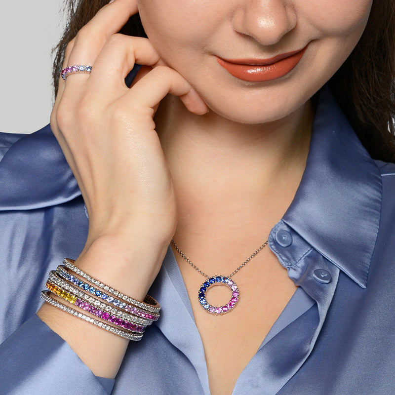 Woman wearing a necklace and bracelets with a neutral background