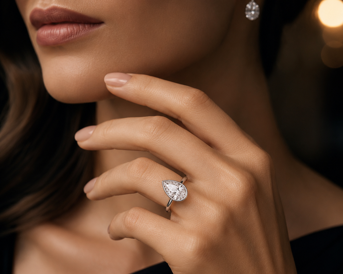 Close-up of a hand wearing a diamond ring with a blurred background