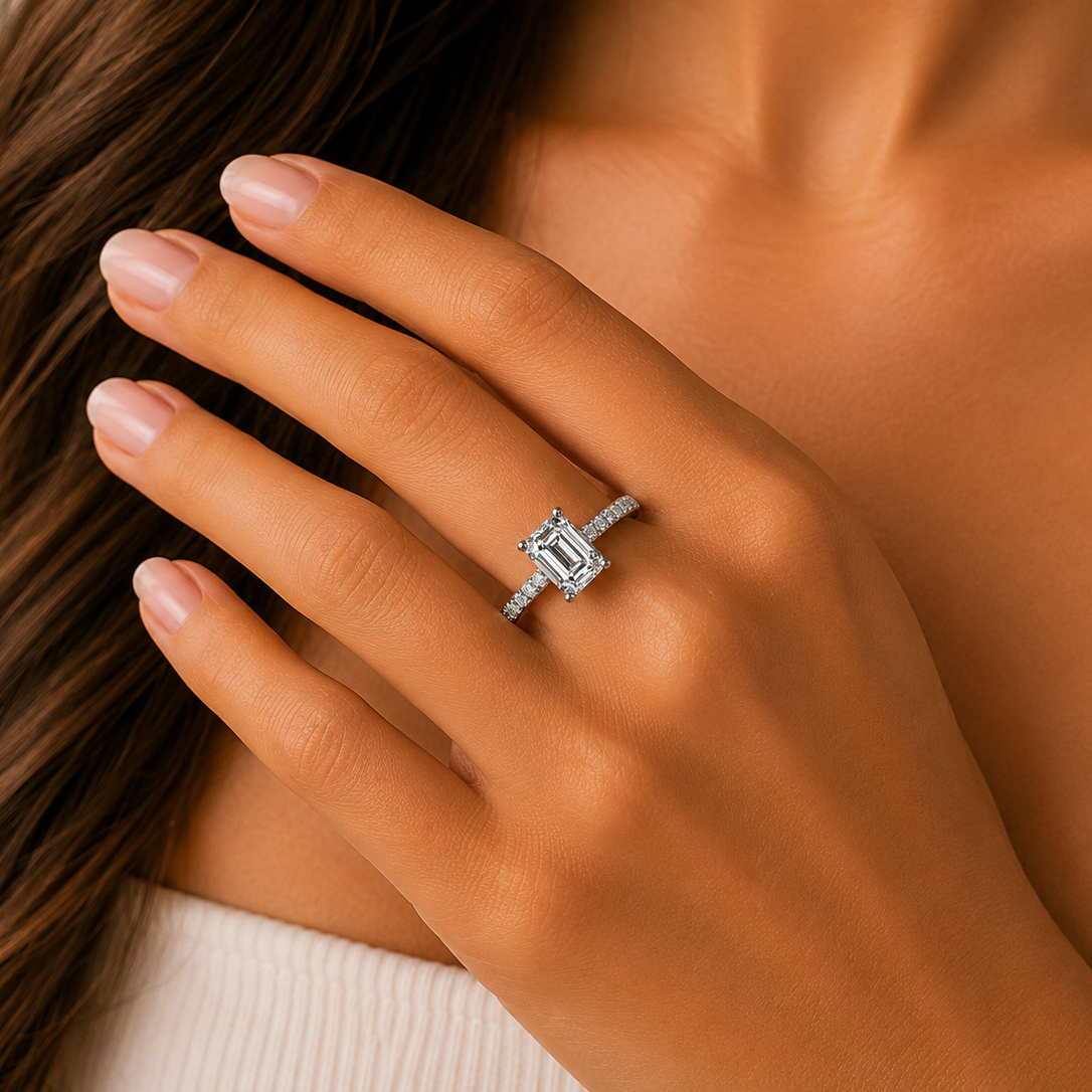 Close-up of a hand wearing a diamond ring with a neutral background