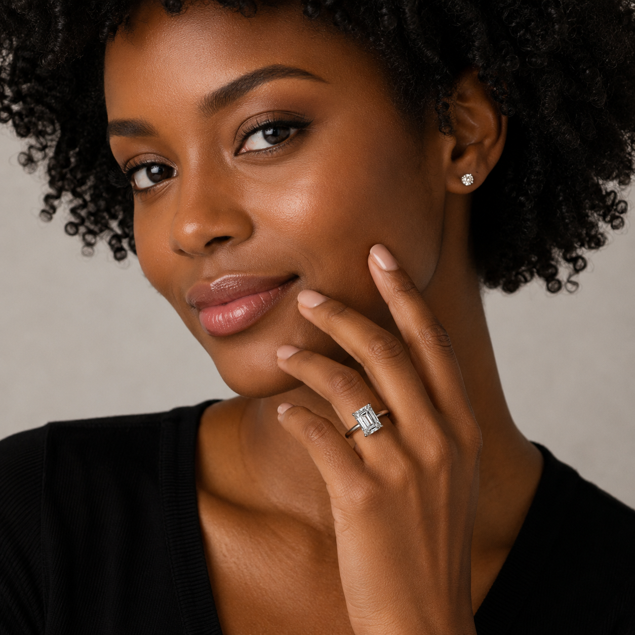 Woman wearing a diamond ring with a neutral background