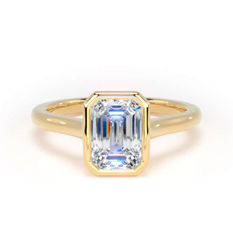 A yellow gold ring featuring a rectangular emerald-cut clear gemstone, set against a clean white background.