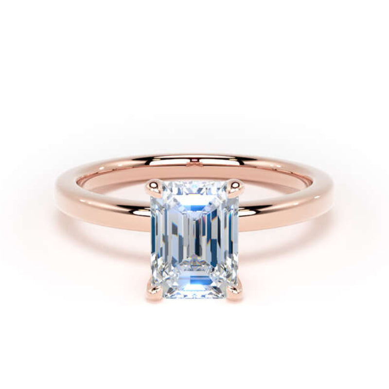 A rose gold engagement ring featuring a rectangular emerald-cut light blue gemstone in a four-prong setting, shown on a clean white background.