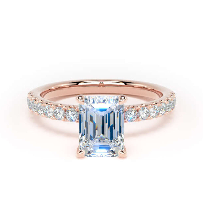 A rose gold engagement ring featuring a large emerald-cut light blue center stone and a pavé band set with small clear stones, shown on a plain white background.