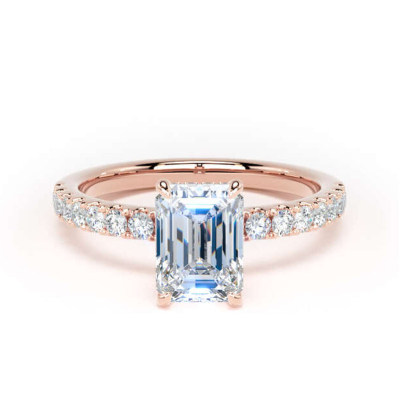 A rose gold engagement ring featuring a large emerald-cut light blue center stone and a pavé band set with small clear stones, shown on a clean white background.