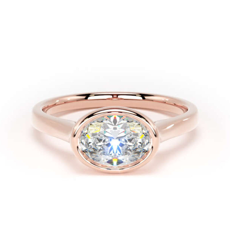 A rose gold oval ring featuring a brilliant round-cut clear gemstone, set against a seamless white background.