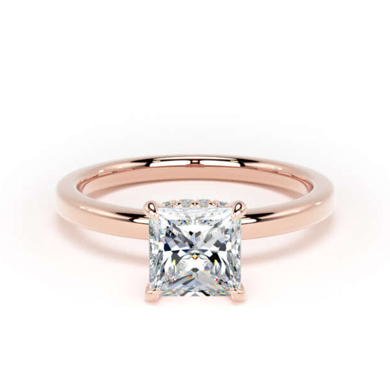 A rose gold solitaire ring featuring a large princess-cut clear gemstone, set against a clean white background.