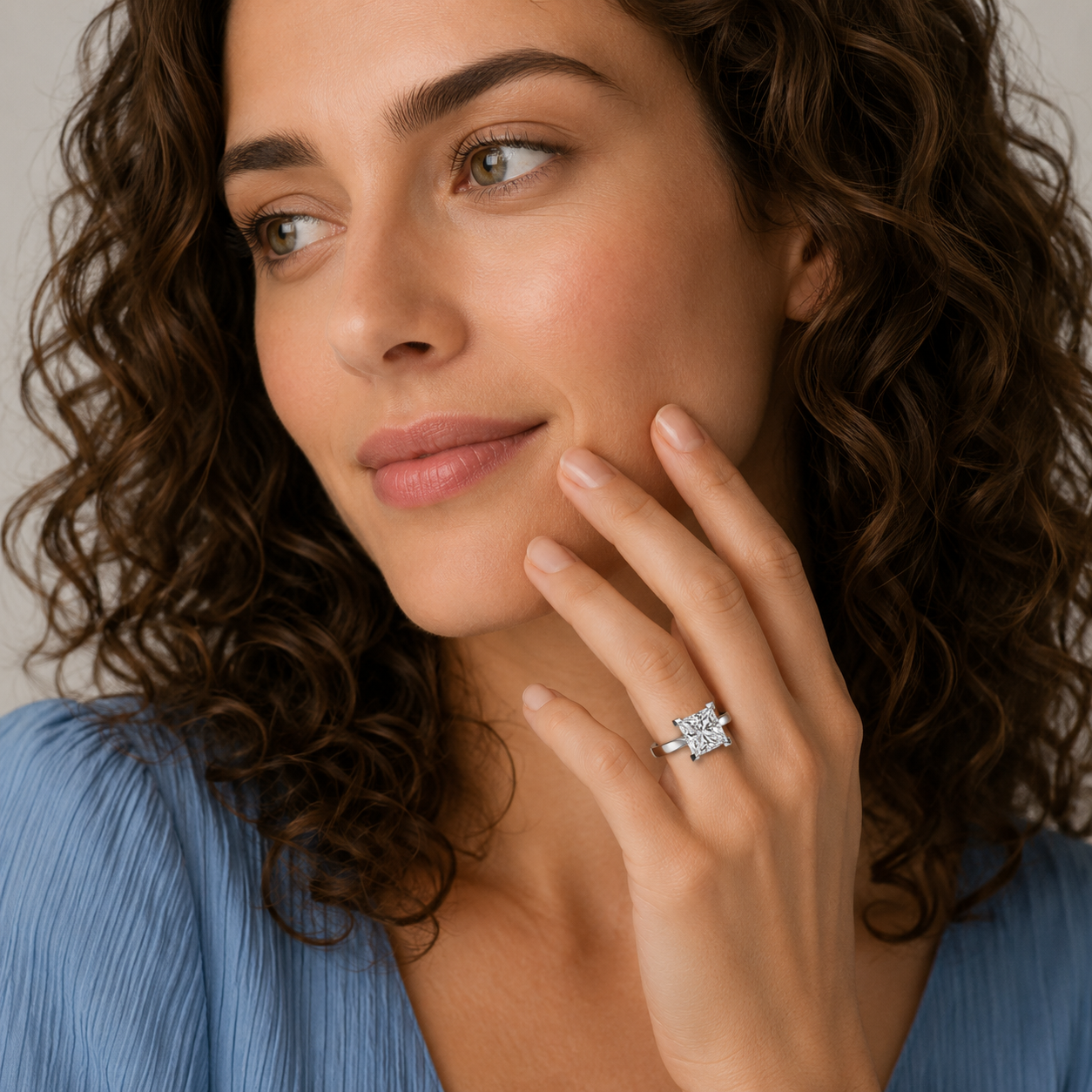 Woman wearing a diamond ring, close-up of face and hand