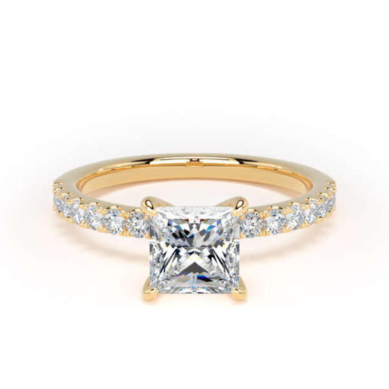 A yellow gold ring featuring a princess-cut clear center stone and a pavé band with small round stones, set against a plain white background.