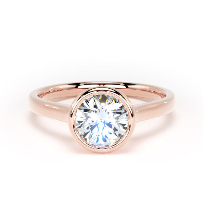 A rose gold solitaire ring with a round brilliant-cut clear gemstone, set in a polished bezel on a white background.