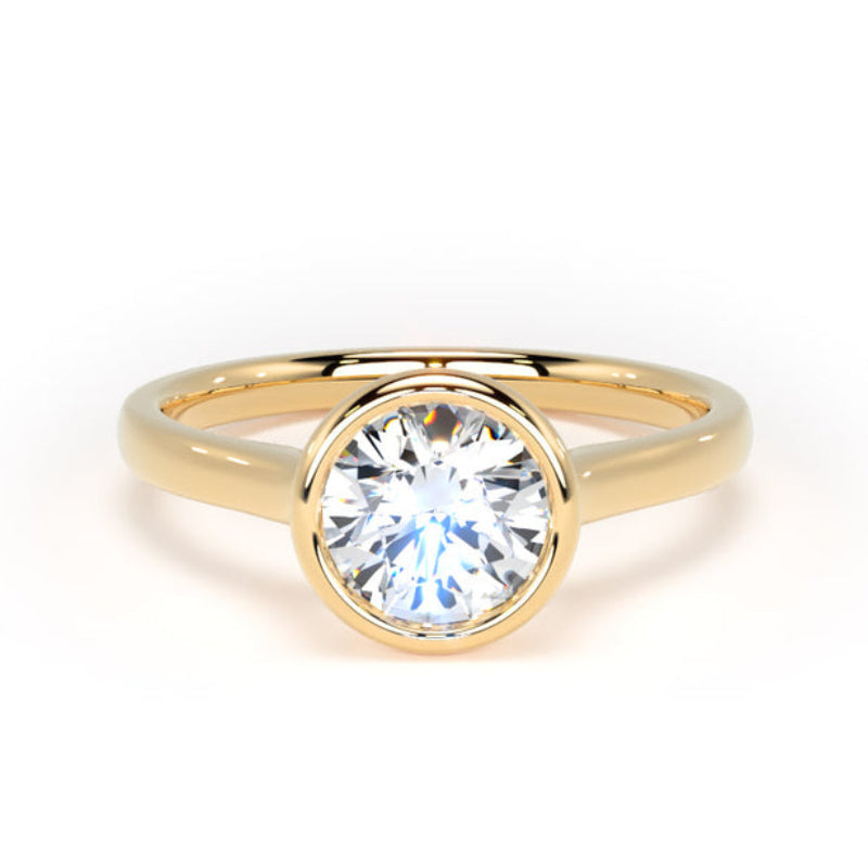 A yellow gold solitaire ring with a round brilliant-cut clear gemstone, set in a bezel-like prong setting on a white background.
