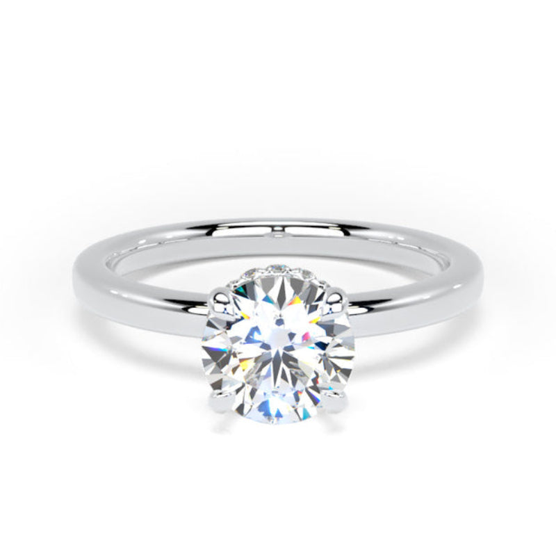 A classic solitaire engagement ring featuring a round brilliant-cut diamond set in a polished white gold or platinum band, shown on a clean white background.
