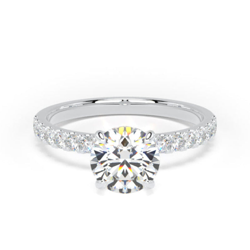 A classic solitaire engagement ring featuring a round brilliant-cut center stone in a silver-toned setting, with a pavé band set with small round stones, shown on a plain white background.